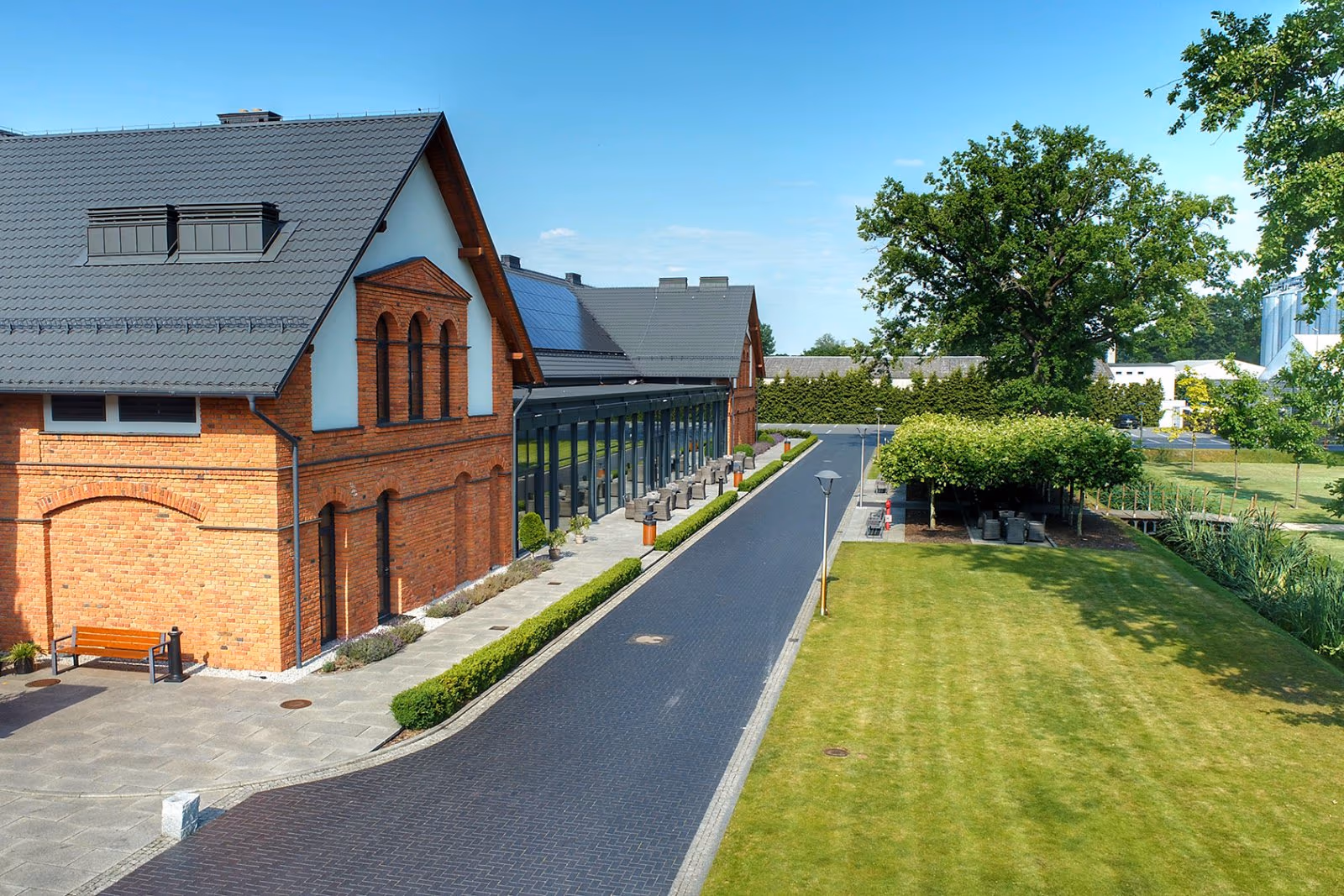 Zabytkowe ceglane budynki folwarku Ostoja Chobienice z lotu ptaka, wśród zieleni